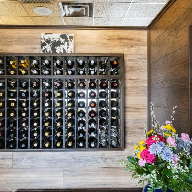 Wine bottle display beside a vase of flowers