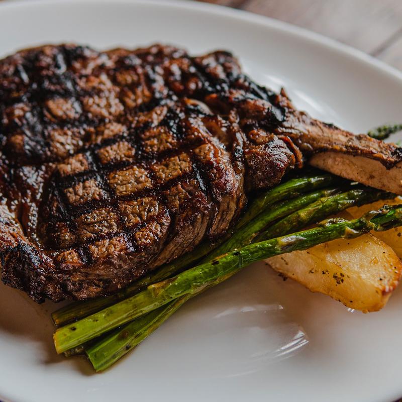 Grilled bone-in steak with asparagus and potatoes